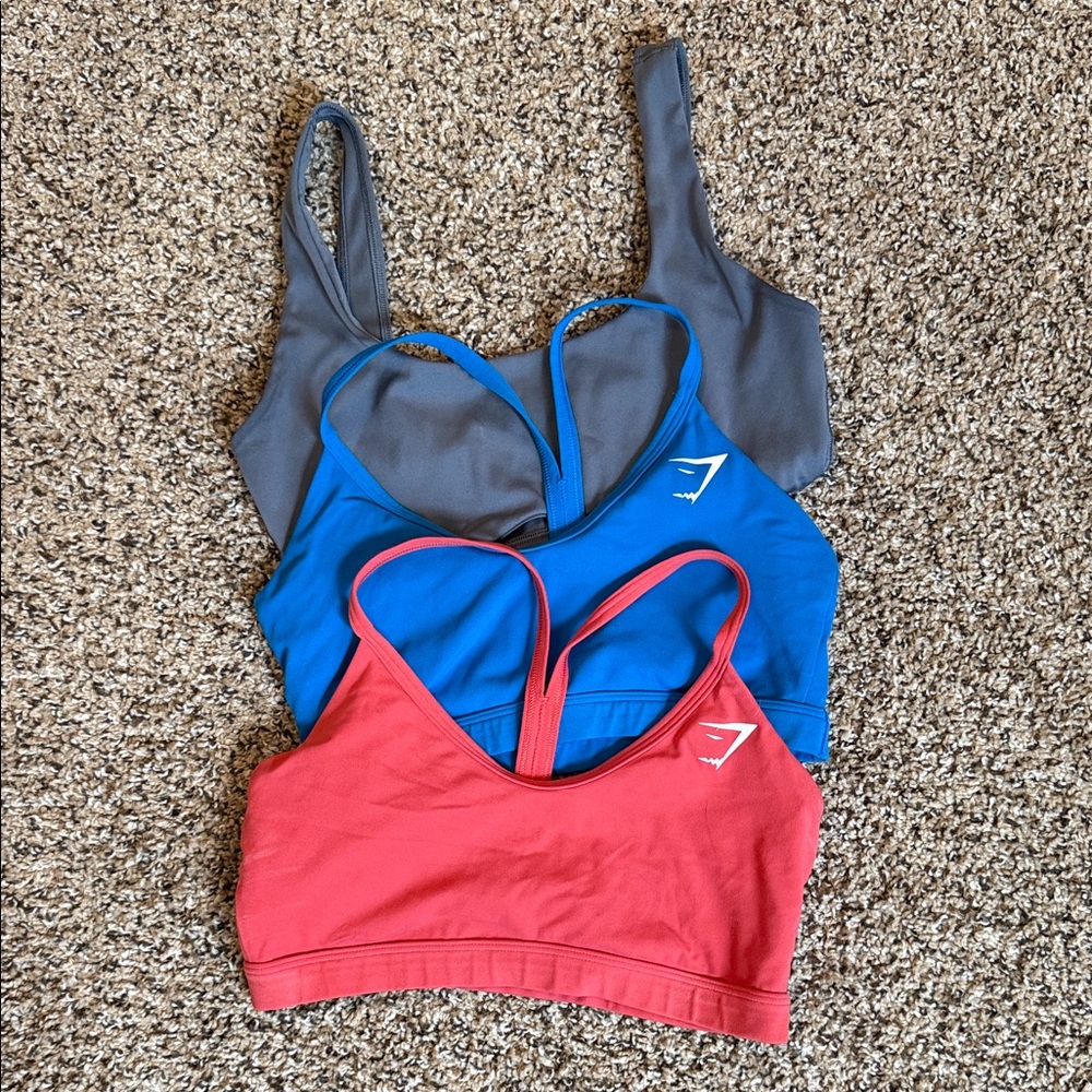 Gymshark Women’s sports bra: Set of 3. Gray, Blue, and Redish/pink. All size S